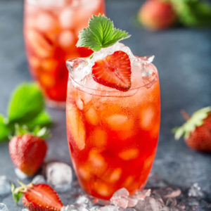 Made with fresh strawberries, sugar, lemon, and mint and mixed with club soda and light rum, this refresing strawberry cocktail will be a hit at your next party! #rumcocktails #strawberrycocktails