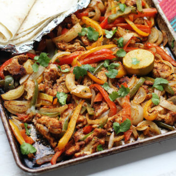 a sheet pan with roasted bell peppers and seasoned chicken