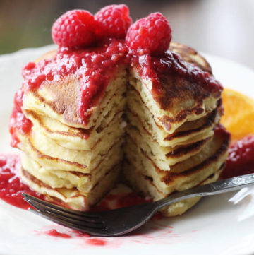 a close up picture of a stack of pancakes on a white plate