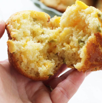 the inside of a cornbread muffin with melted cheddar and chopped jalapeno peppers