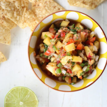 overhead picture of a bowl of fresh peach salsa next to tortilla chips
