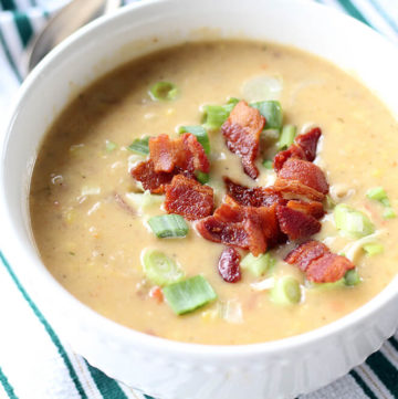 cropped pic of soup in a bowl with bacon and green onions on top