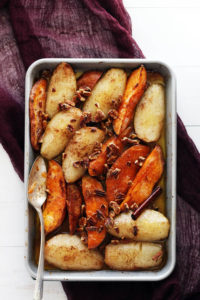 overhead picture of a sheet pan with pears and sweet potatoes with cinnamon and pecans